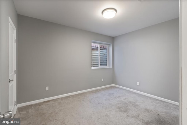 spare room with light carpet and baseboards