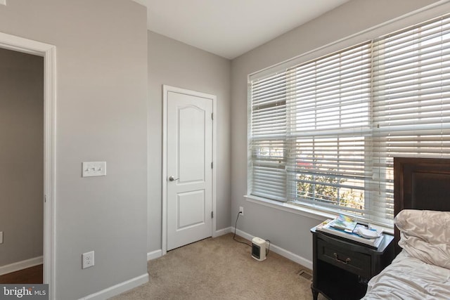 bedroom with light carpet, visible vents, and baseboards