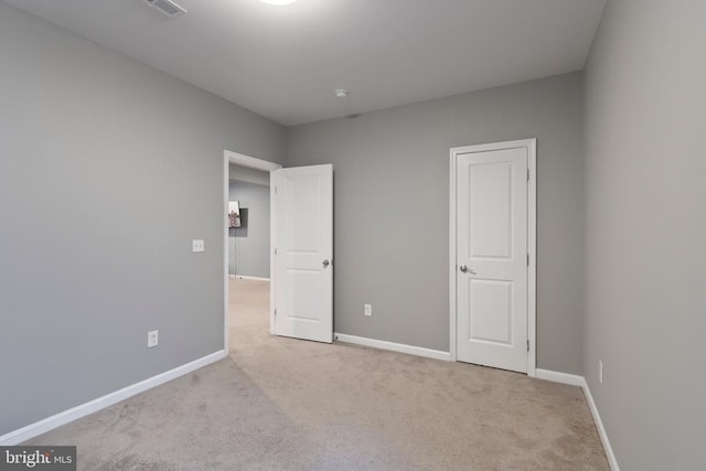 unfurnished bedroom featuring light carpet and baseboards