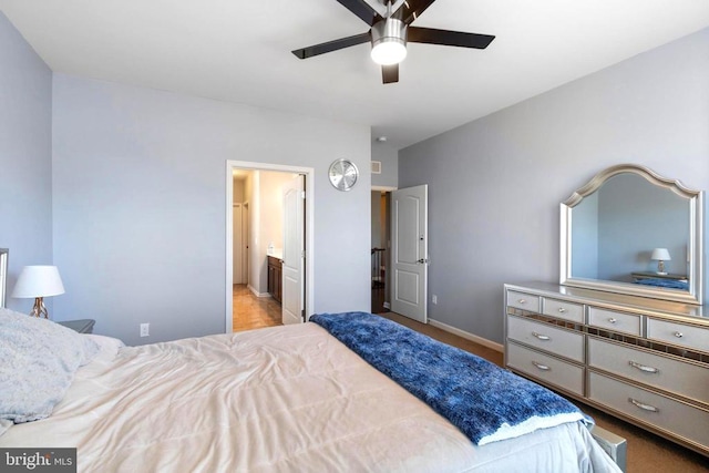 bedroom with ensuite bath, baseboards, and a ceiling fan