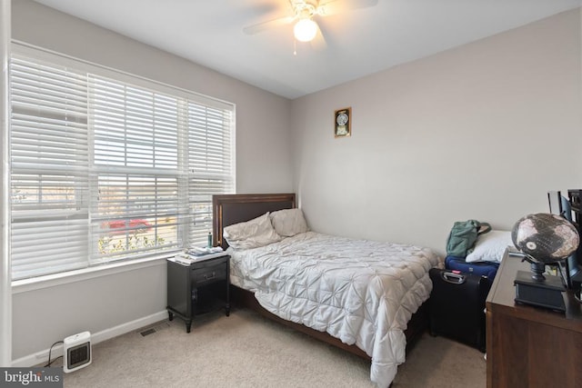 bedroom featuring light carpet, baseboards, and a ceiling fan