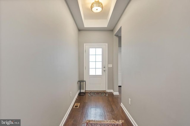 doorway featuring dark wood-style flooring, visible vents, and baseboards