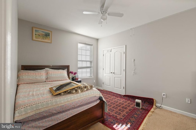 carpeted bedroom with ceiling fan, a closet, and baseboards