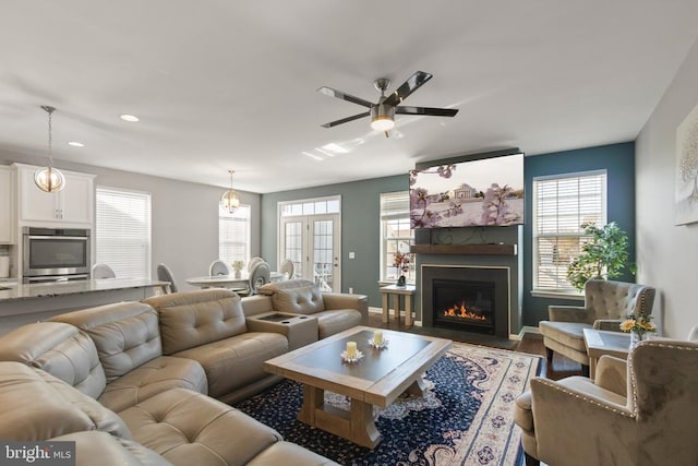 living room with recessed lighting, a fireplace with flush hearth, ceiling fan, wood finished floors, and baseboards