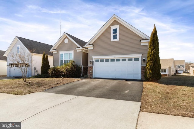 traditional-style home with a garage, driveway, and stone siding