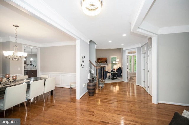 foyer entrance featuring an inviting chandelier, crown molding, and wood-type flooring