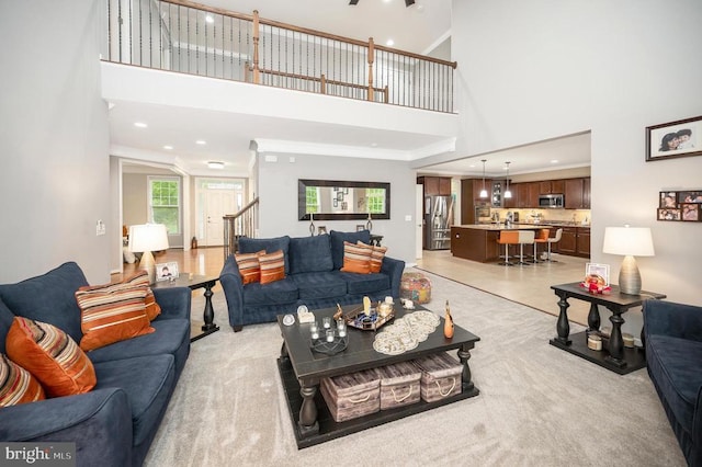 carpeted living room with a towering ceiling