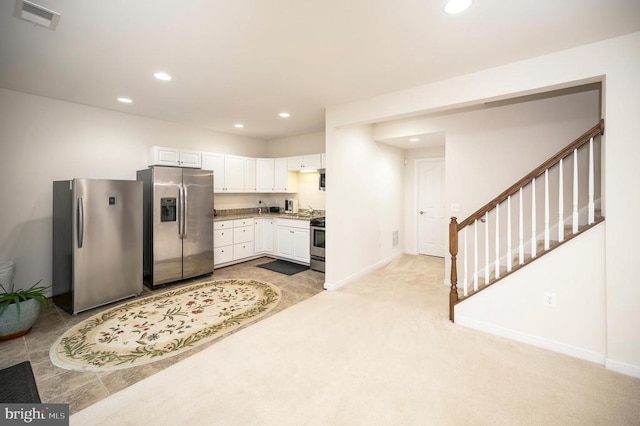 kitchen with white cabinetry, light colored carpet, appliances with stainless steel finishes, and light stone countertops