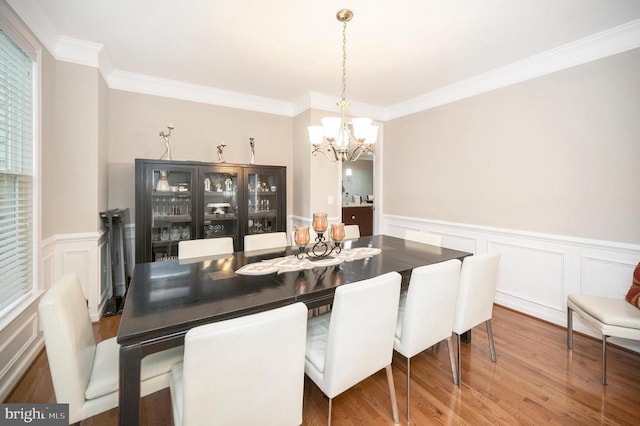 dining room with crown molding, a chandelier, and hardwood / wood-style floors