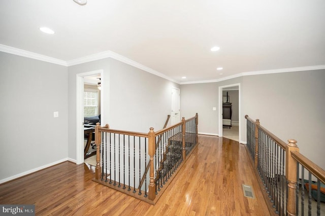 corridor featuring ornamental molding and hardwood / wood-style floors