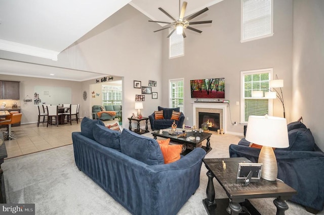 tiled living room with crown molding, ceiling fan, and a towering ceiling