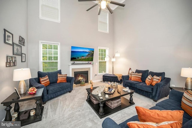 living room with light colored carpet, ceiling fan, and a high ceiling