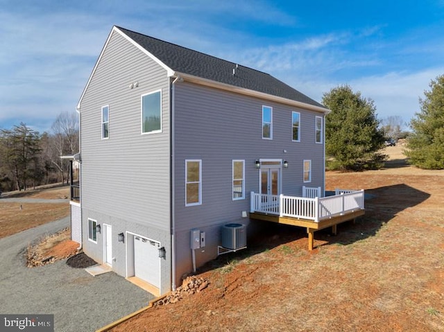 rear view of house with an attached garage and a wooden deck