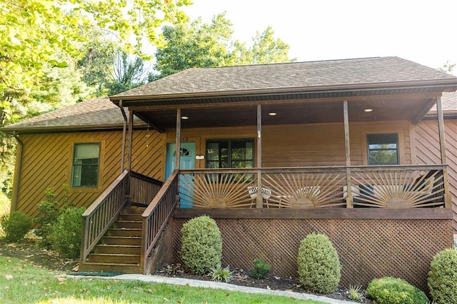 view of front of property with stairs and roof with shingles