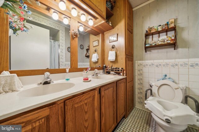 bathroom with vanity, tile patterned floors, toilet, and tile walls