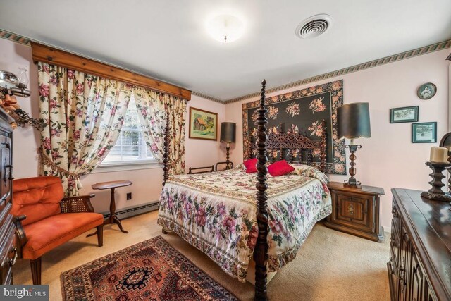 bedroom with light carpet and baseboard heating