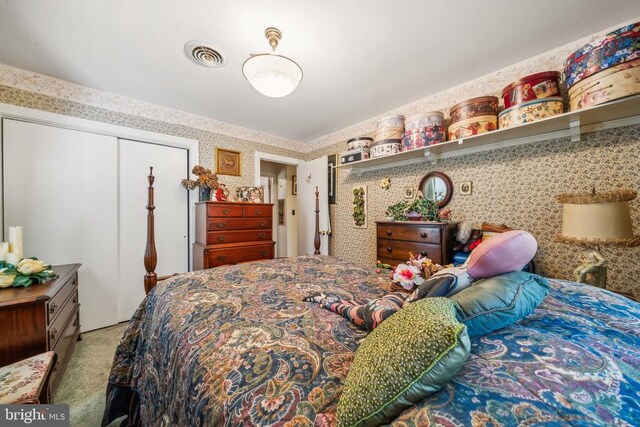 bedroom with light carpet and a closet