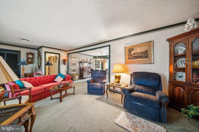 living room featuring crown molding, carpet flooring, and a chandelier