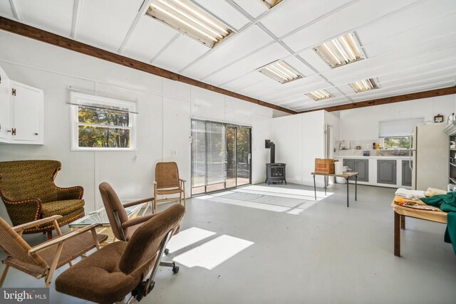 living area featuring concrete floors and a wood stove