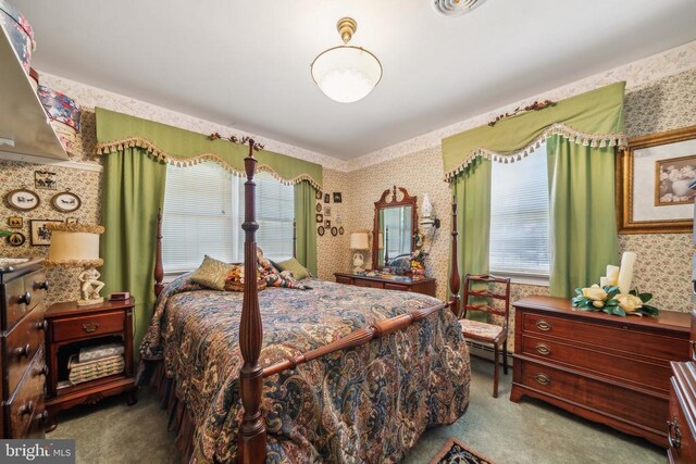 bedroom with carpet and a baseboard heating unit