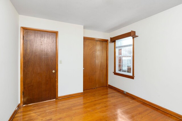 unfurnished bedroom with a closet and light hardwood / wood-style flooring