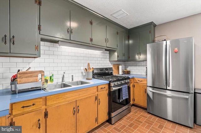 kitchen featuring a sink, decorative backsplash, brick patterned floor, and stainless steel appliances
