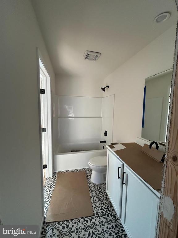 full bathroom featuring tile patterned flooring, vanity, tub / shower combination, and toilet