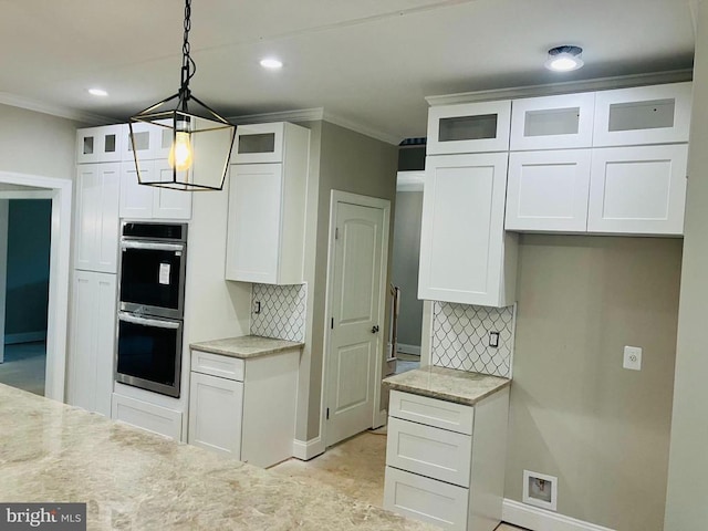 kitchen with hanging light fixtures, glass insert cabinets, and white cabinets