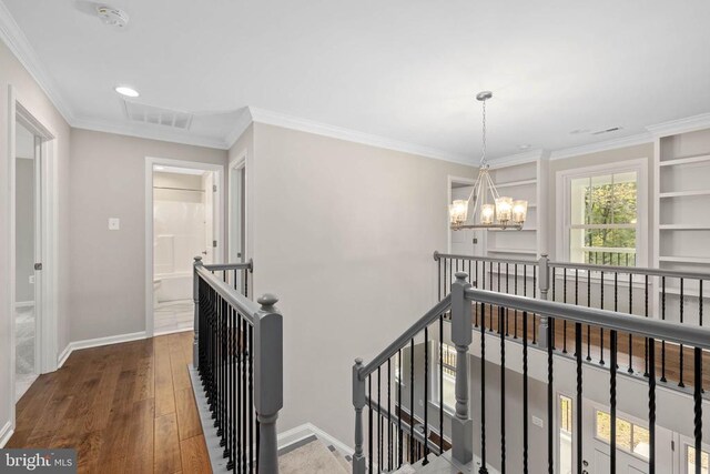 hallway featuring ornamental molding, dark hardwood / wood-style floors, and a chandelier