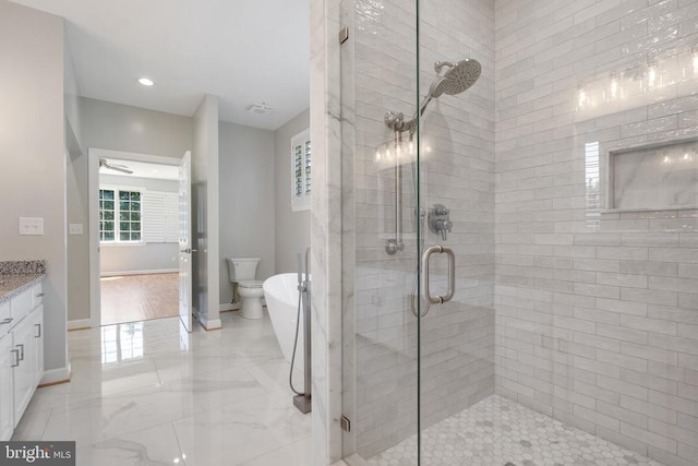 full bathroom with a freestanding bath, vanity, marble finish floor, baseboards, and a stall shower