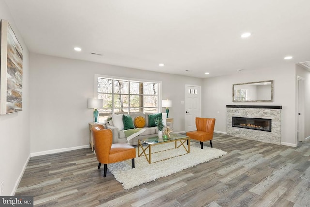 living area with recessed lighting, baseboards, and wood finished floors