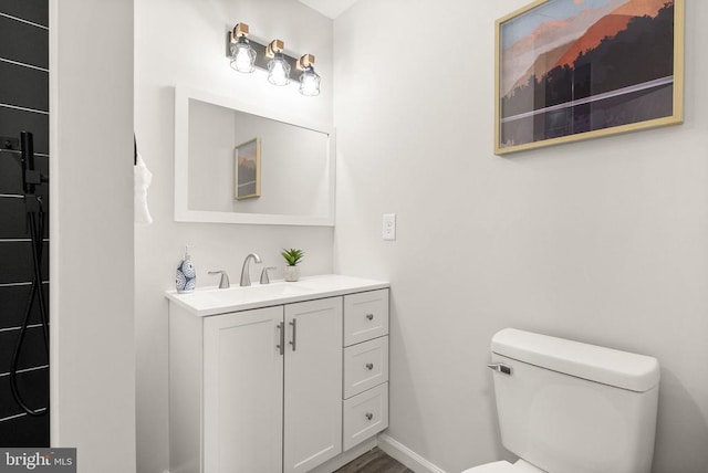 bathroom featuring baseboards, toilet, and vanity