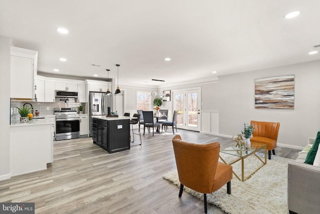 living area with light wood finished floors, recessed lighting, and baseboards