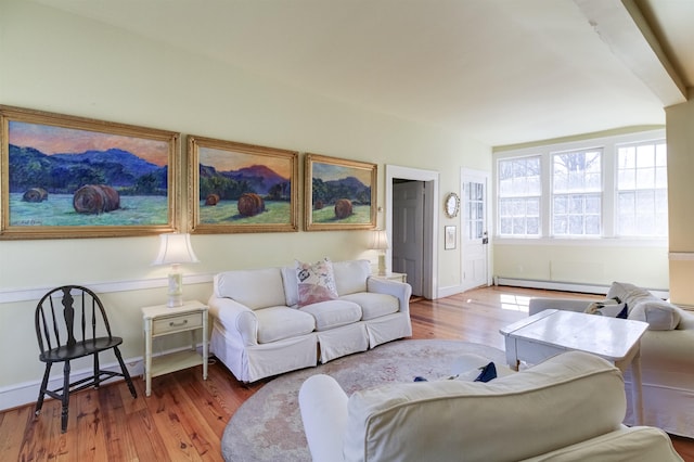 living room featuring wood-type flooring and baseboard heating