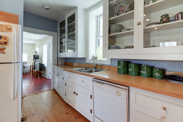 kitchen with sink, white cabinetry, light hardwood / wood-style flooring, white appliances, and a baseboard heating unit