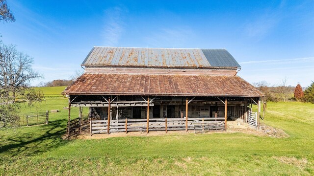 view of front of home with an outdoor structure and a rural view