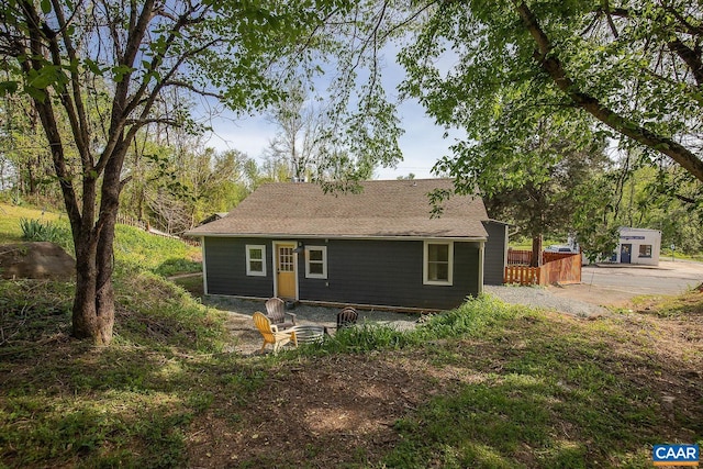 rear view of house featuring roof with shingles