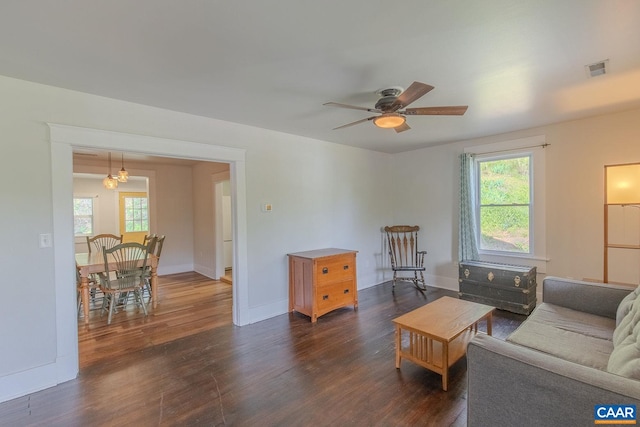 living area with visible vents, a ceiling fan, baseboards, and dark wood-style floors