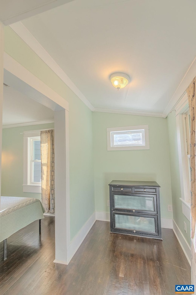 interior space with crown molding, baseboards, and wood finished floors