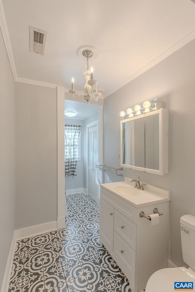 bathroom featuring visible vents, vanity, an inviting chandelier, toilet, and baseboards