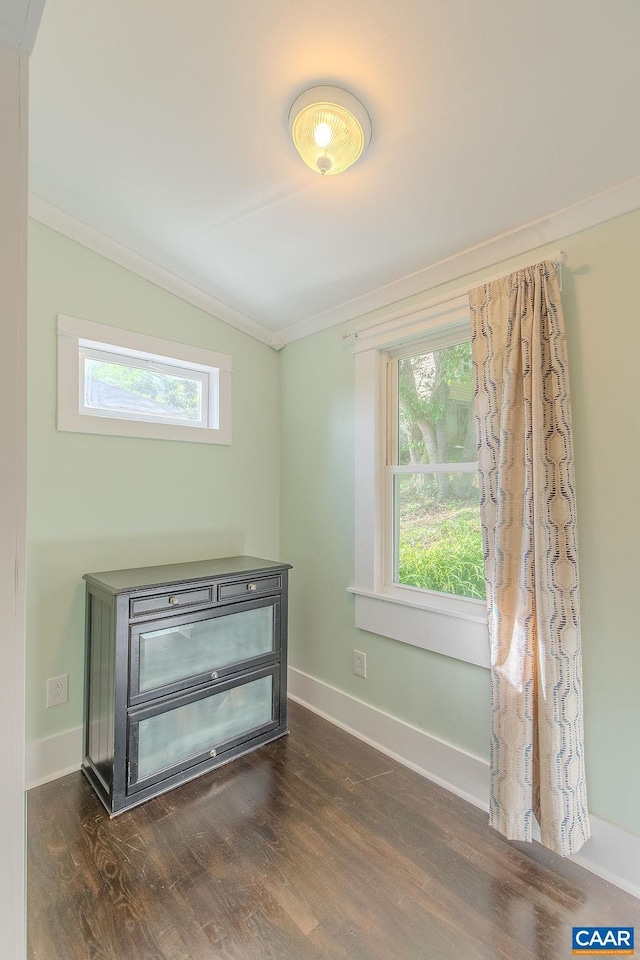 interior space featuring baseboards, ornamental molding, and wood finished floors