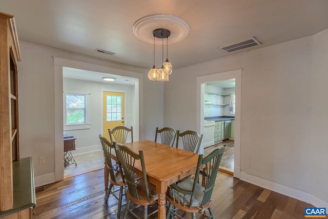 dining space featuring baseboards, visible vents, and wood finished floors