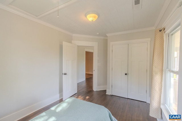 bedroom featuring visible vents, ornamental molding, dark wood-style flooring, a closet, and baseboards
