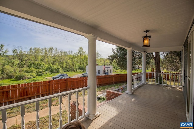 deck with a porch and a fenced backyard