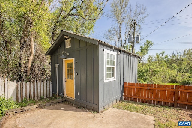 view of outbuilding with fence and an outbuilding
