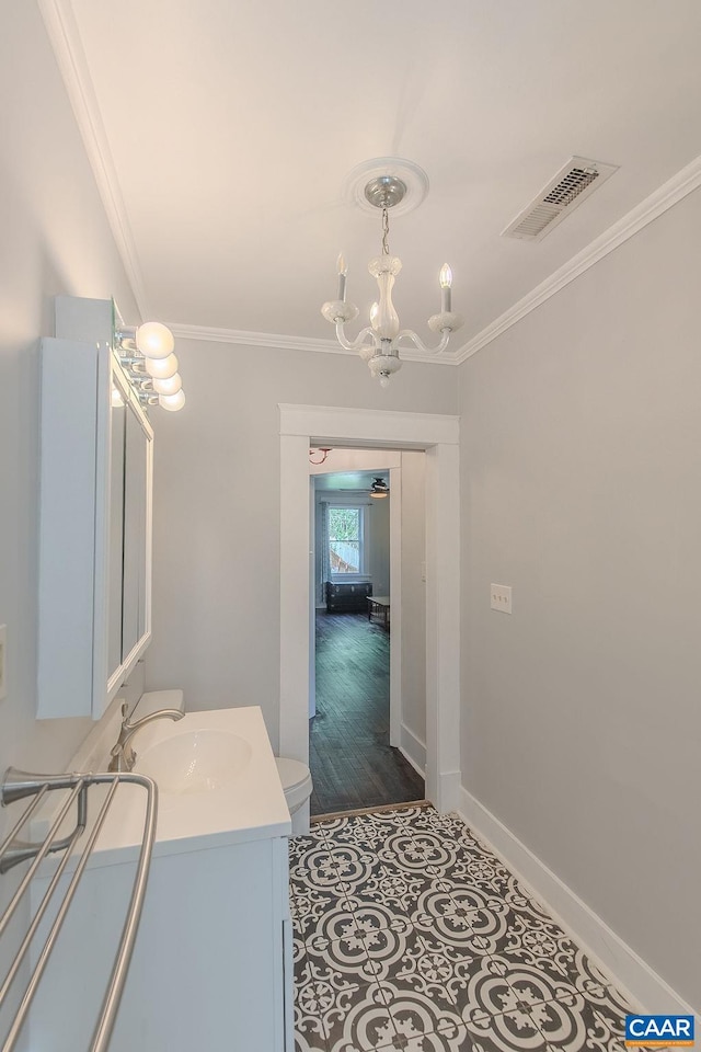 bathroom with crown molding, vanity, a chandelier, and visible vents
