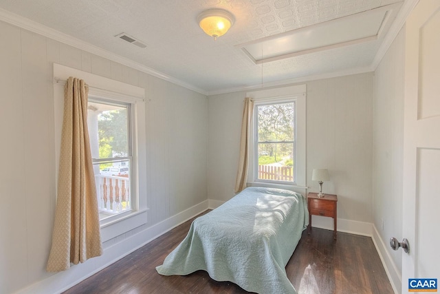 bedroom featuring visible vents, multiple windows, wood finished floors, and attic access