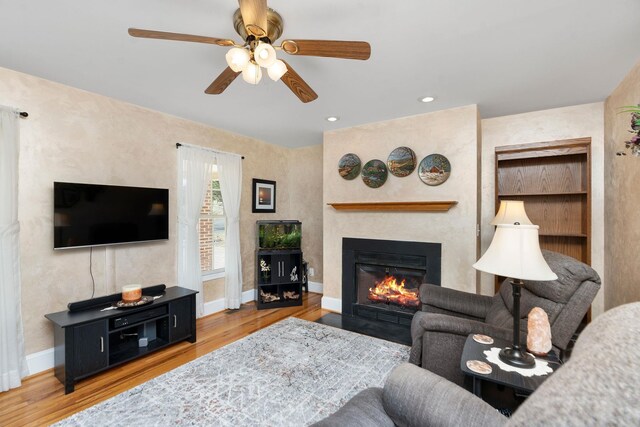 living room with ceiling fan and light hardwood / wood-style floors