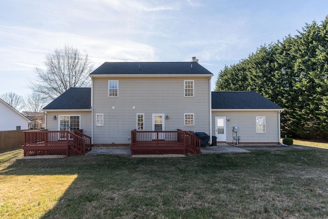 rear view of house with a patio area, a lawn, and a deck