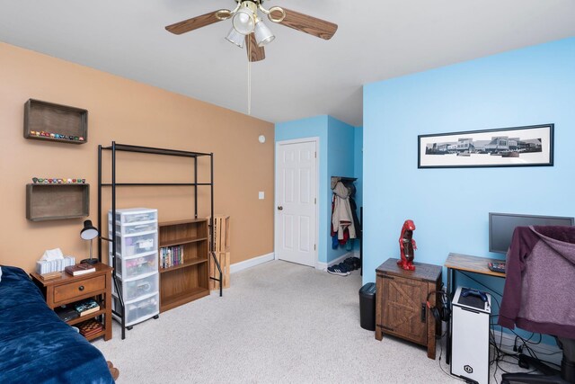 carpeted office space featuring ceiling fan